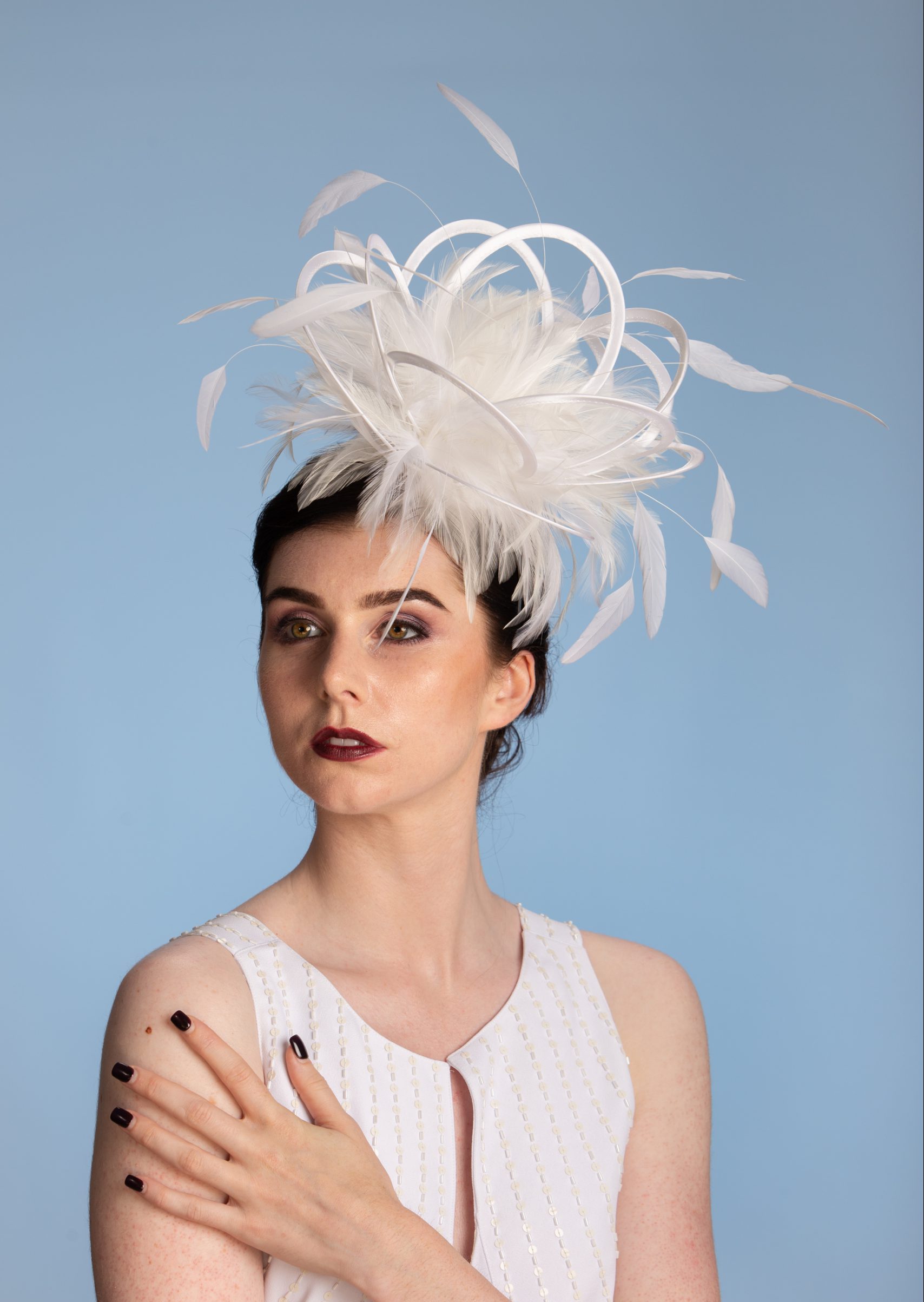 white satin loop and feather fascinator hat set on a headband
